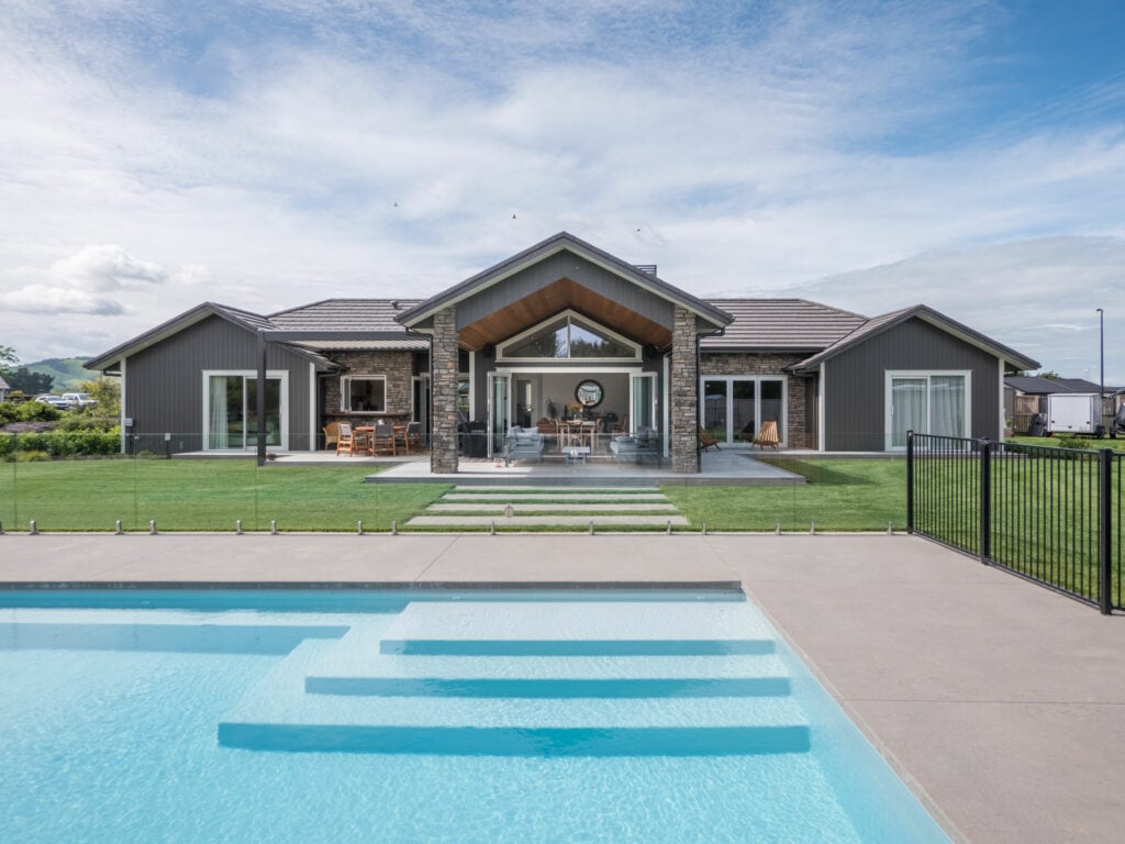 Closeup of pool in backyard of modern black house built be Builders in Te Awamutu